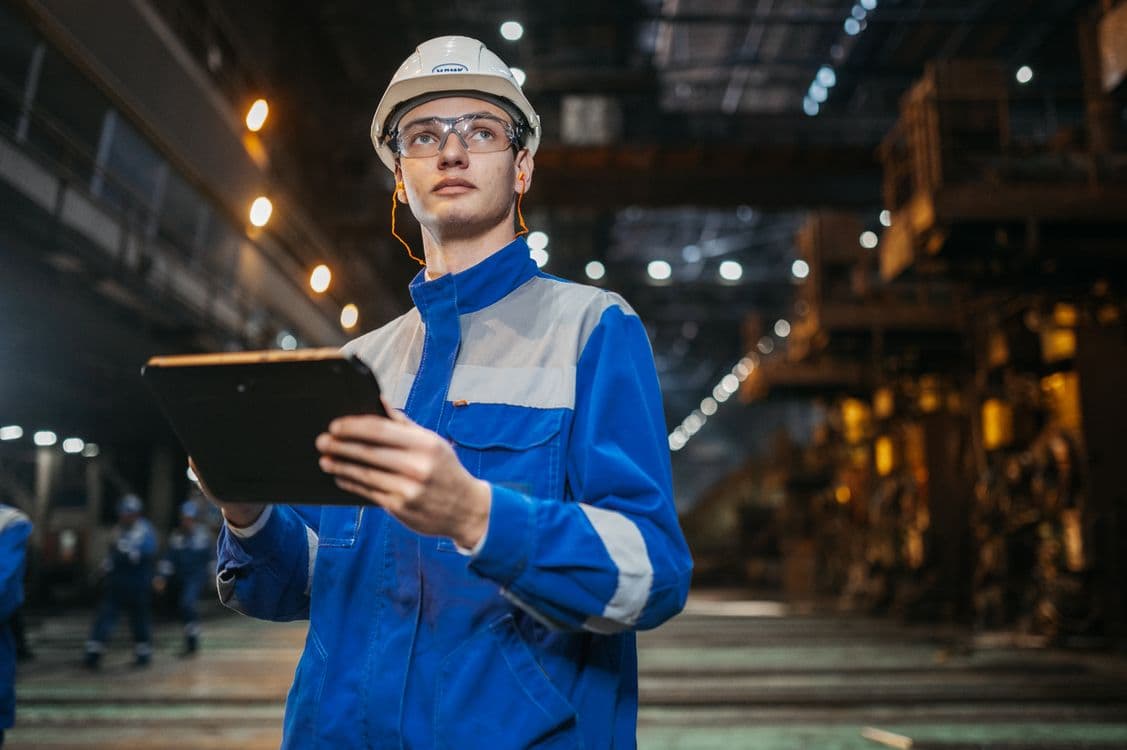 Engineer using an industrial tablet in a connected technology environment